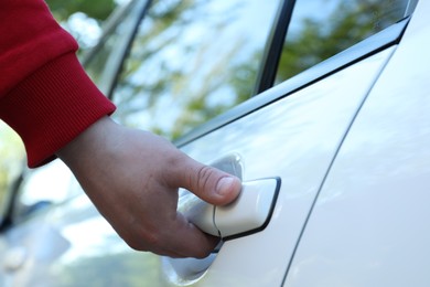 Photo of Closeup view of man opening car door outdoors