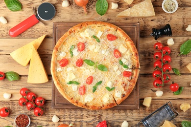 Photo of Composition with delicious pizza and ingredients on wooden background, top view