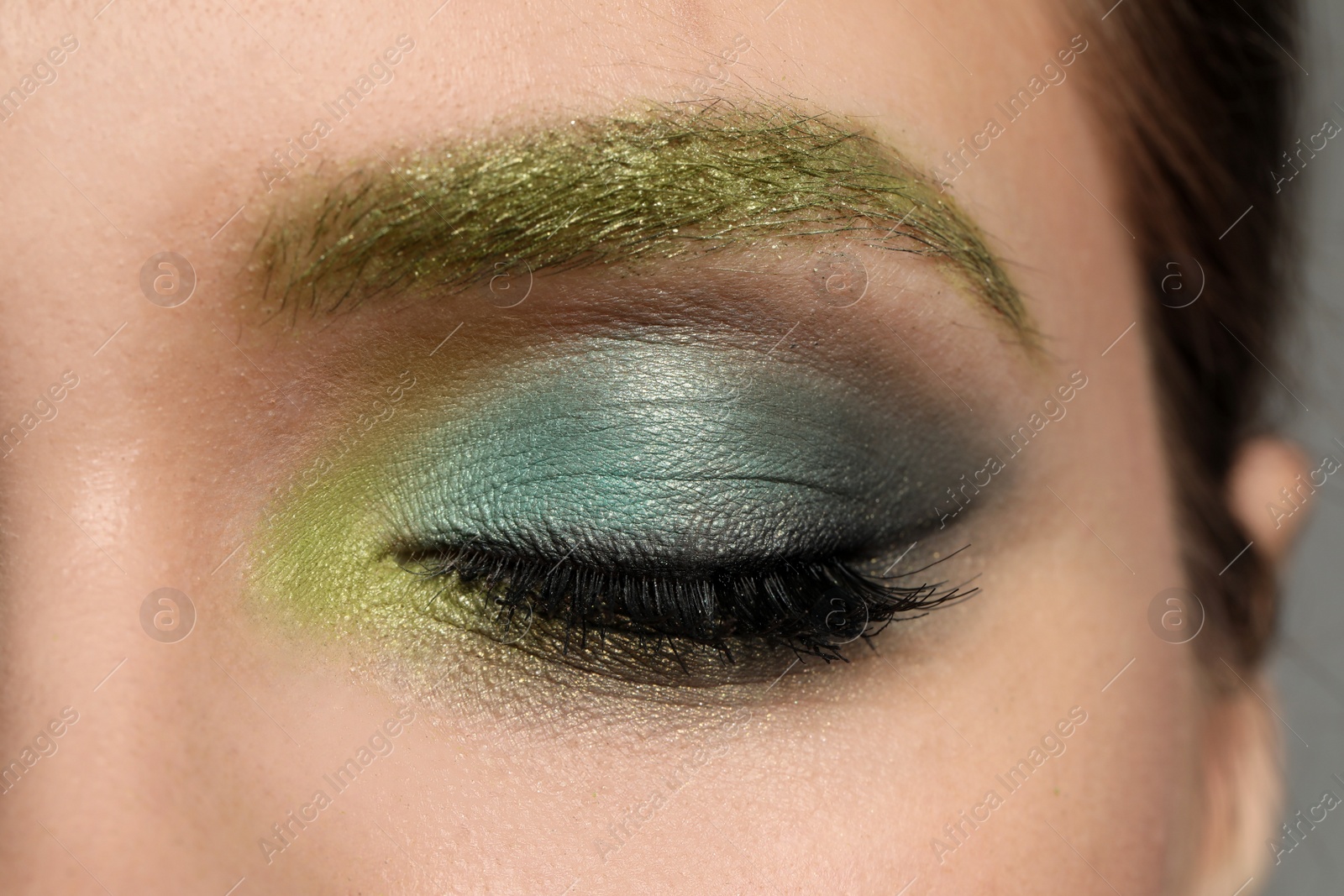 Photo of Young woman with evening makeup, closeup. Eye shadow product