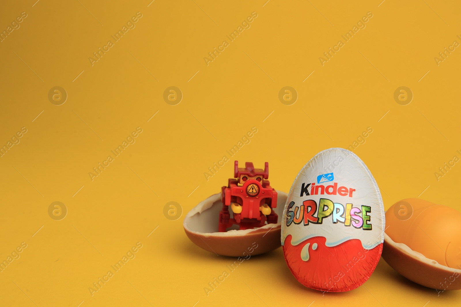 Photo of Sveti Vlas, Bulgaria - July 3, 2023: Kinder Surprise Eggs, plastic capsule and toy on yellow background, space for text