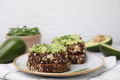 Delicious sandwiches with guacamole and arugula on table, closeup