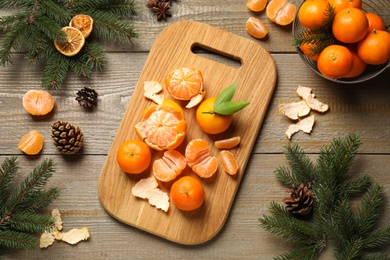 Photo of Flat lay Christmas composition with fresh tangerines and fir tree branches on wooden table