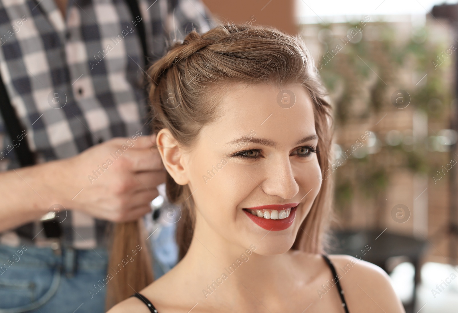 Photo of Professional hairdresser working with client in beauty salon