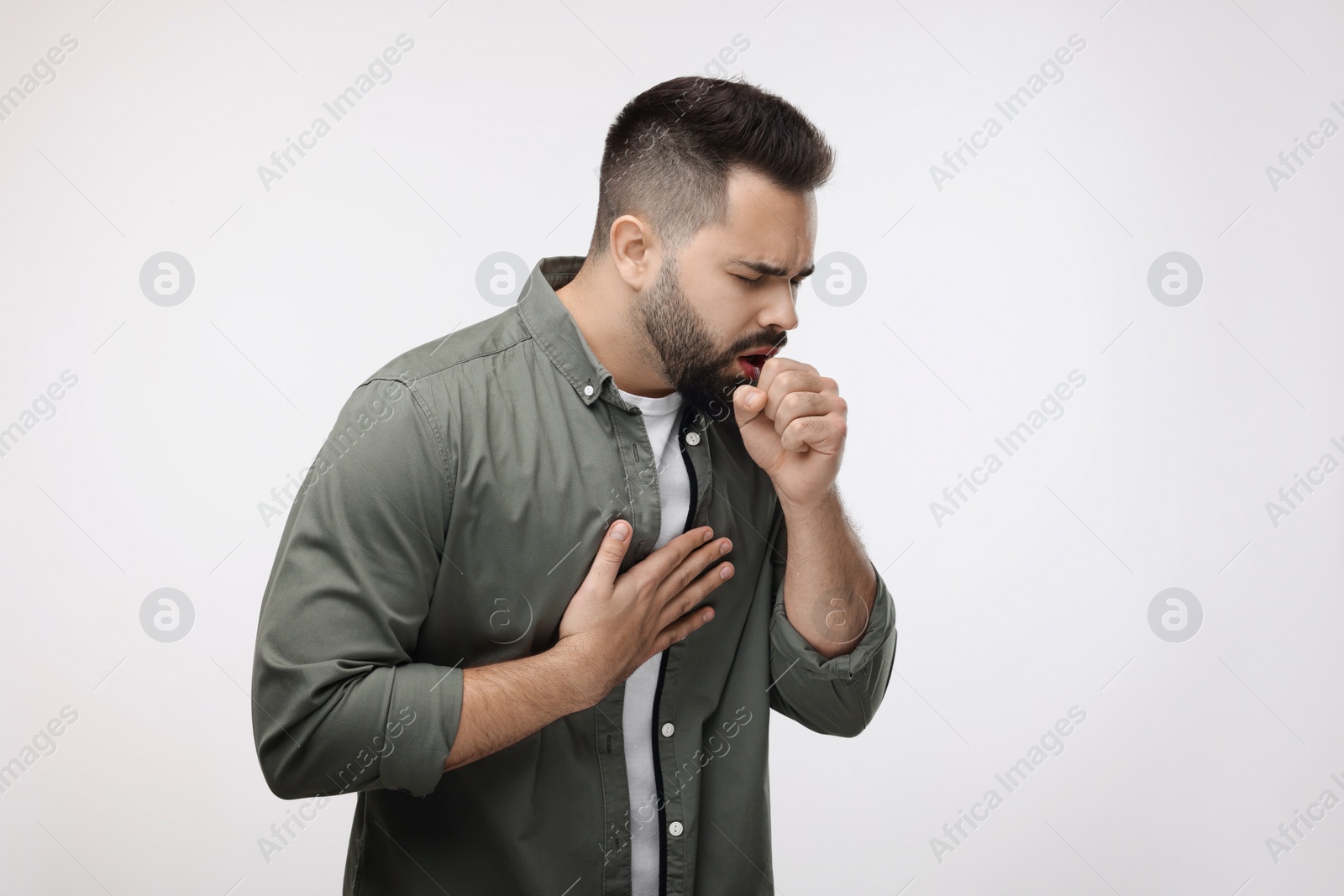 Photo of Sick man coughing on white background. Cold symptoms