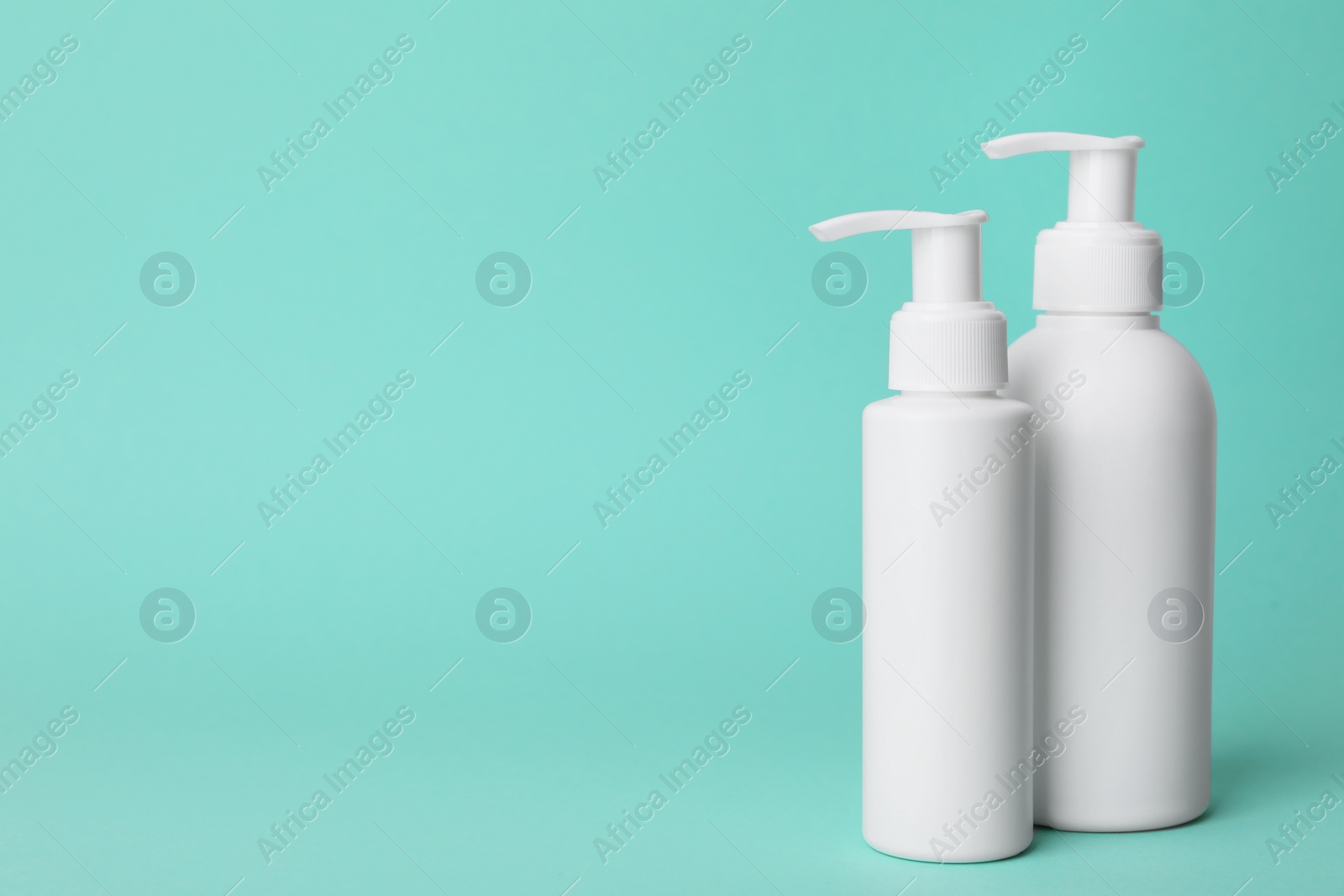 Photo of Different cleansers on turquoise background, space for text. Cosmetic product