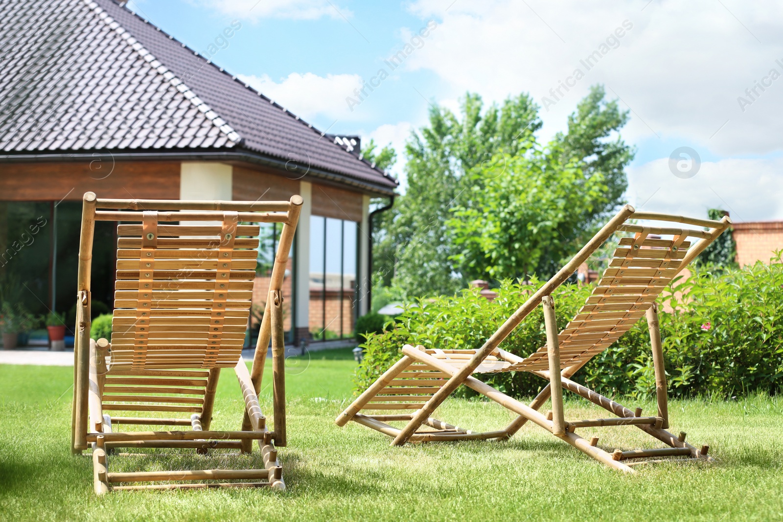 Photo of Wooden deck chairs in beautiful garden on sunny day