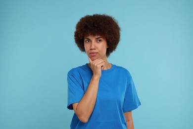 Photo of Portrait of thoughtful young woman on light blue background