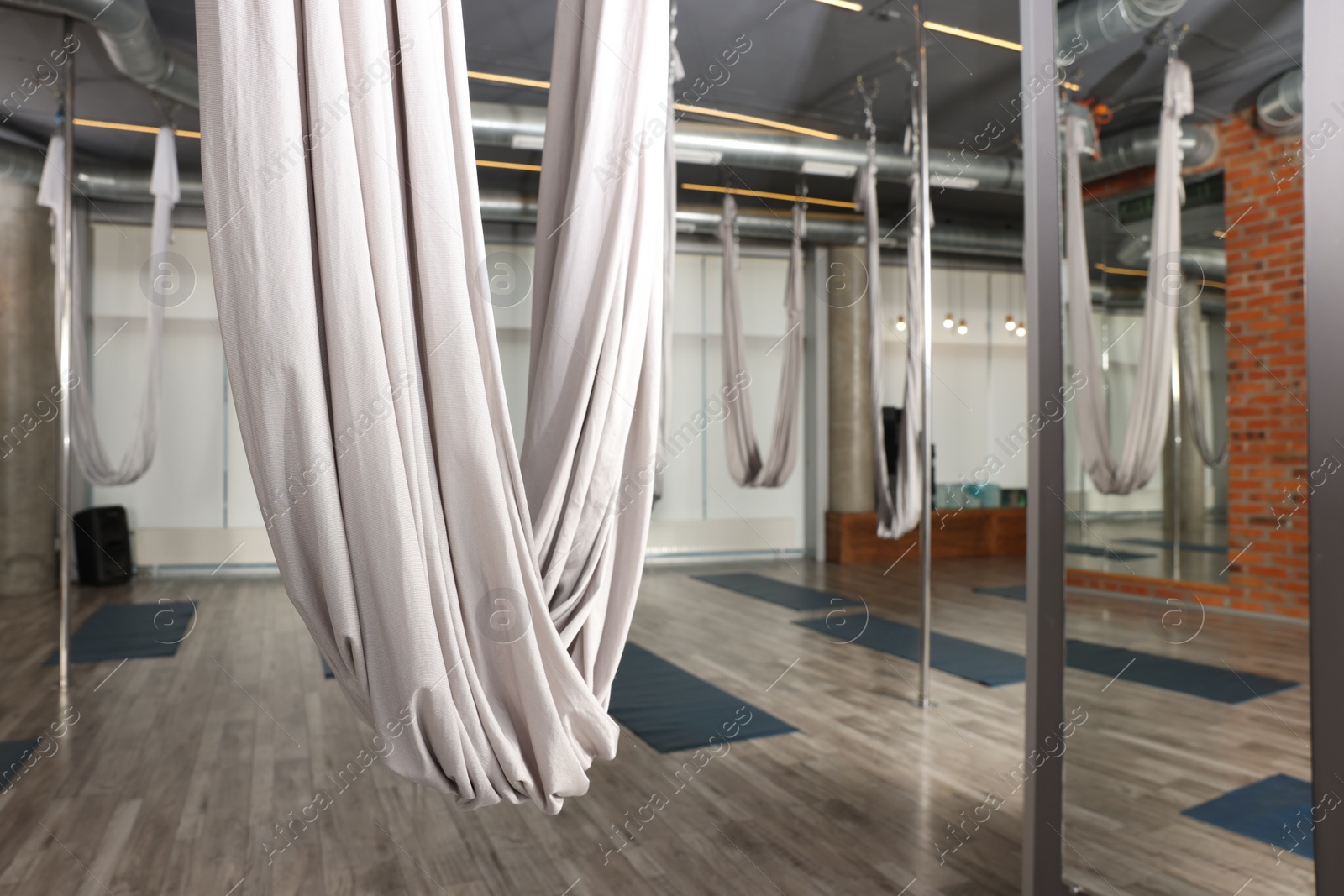 Photo of Many hammocks for fly yoga in studio, space for text