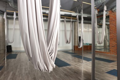 Photo of Many hammocks for fly yoga in studio, space for text