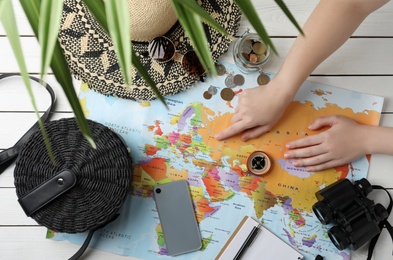 Woman with world map and accessories at table, top view. Travel during summer vacation