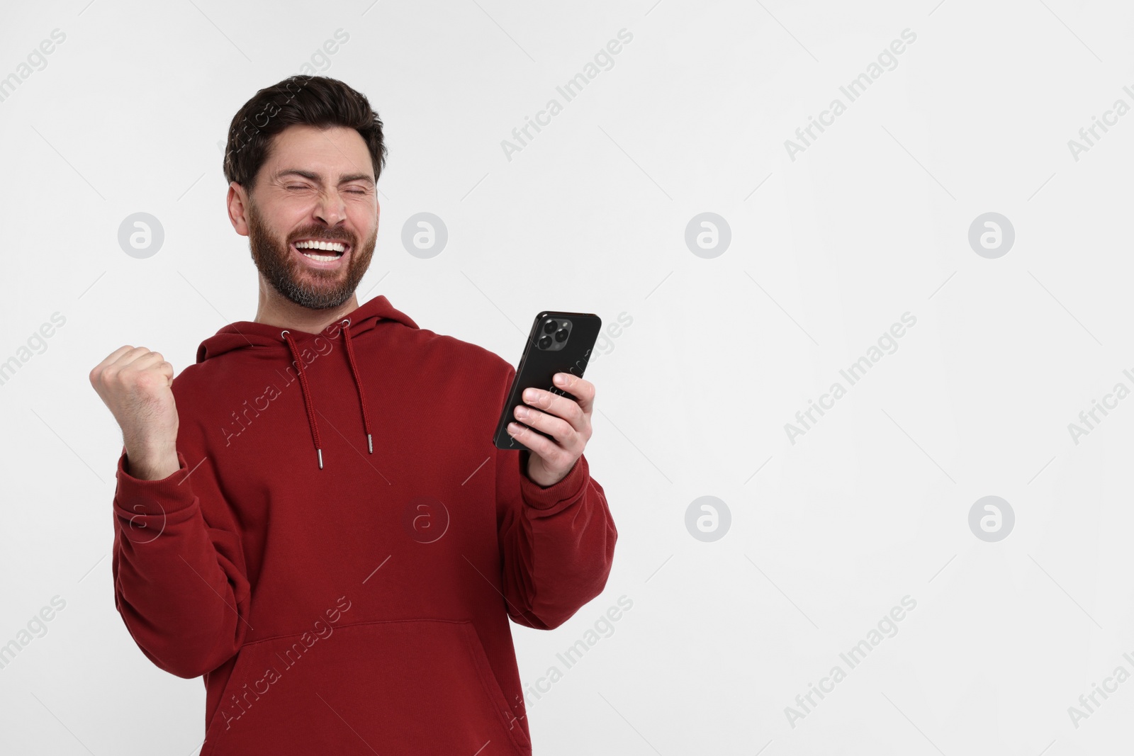 Photo of Happy man with smartphone on white background. Space for text