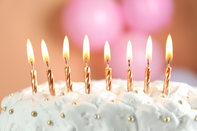 Photo of Birthday cake with burning candles on blurred background, closeup