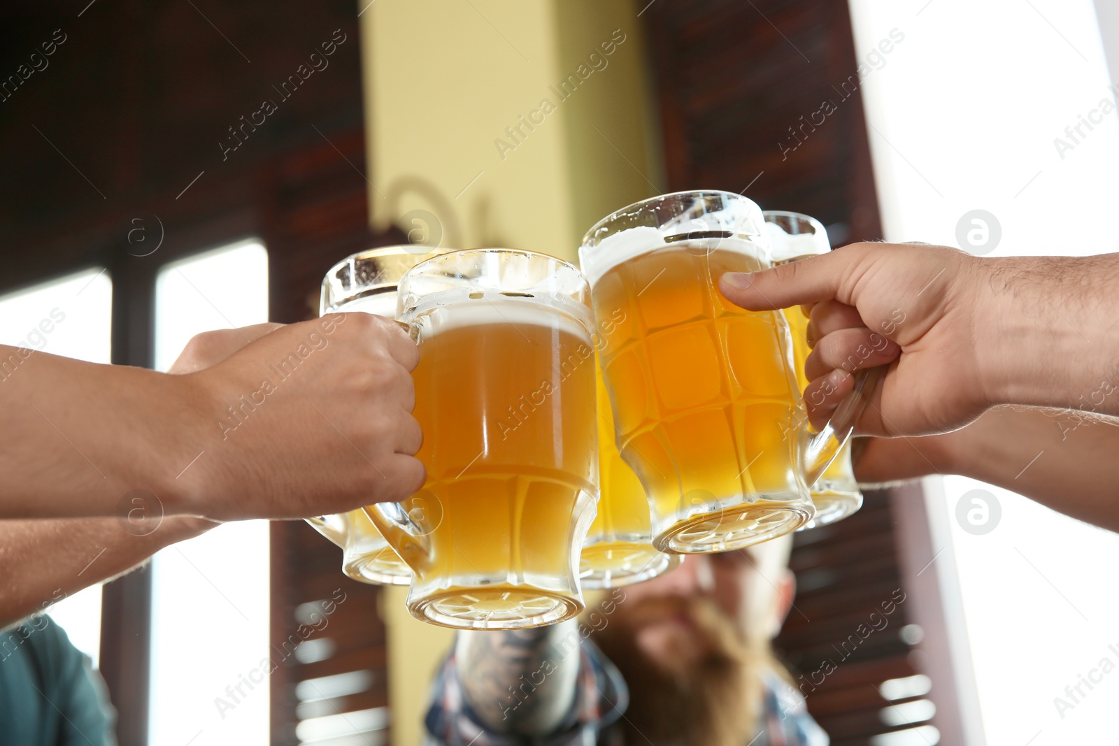 Photo of Friends clinking glasses with beer in pub