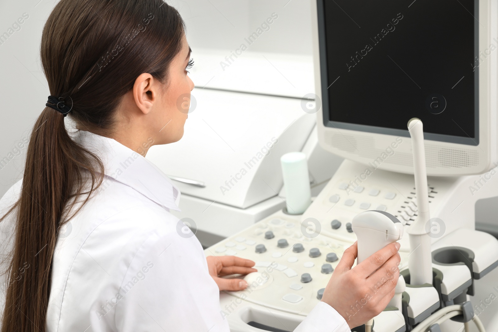 Photo of Professional sonographer using modern ultrasound machine in clinic