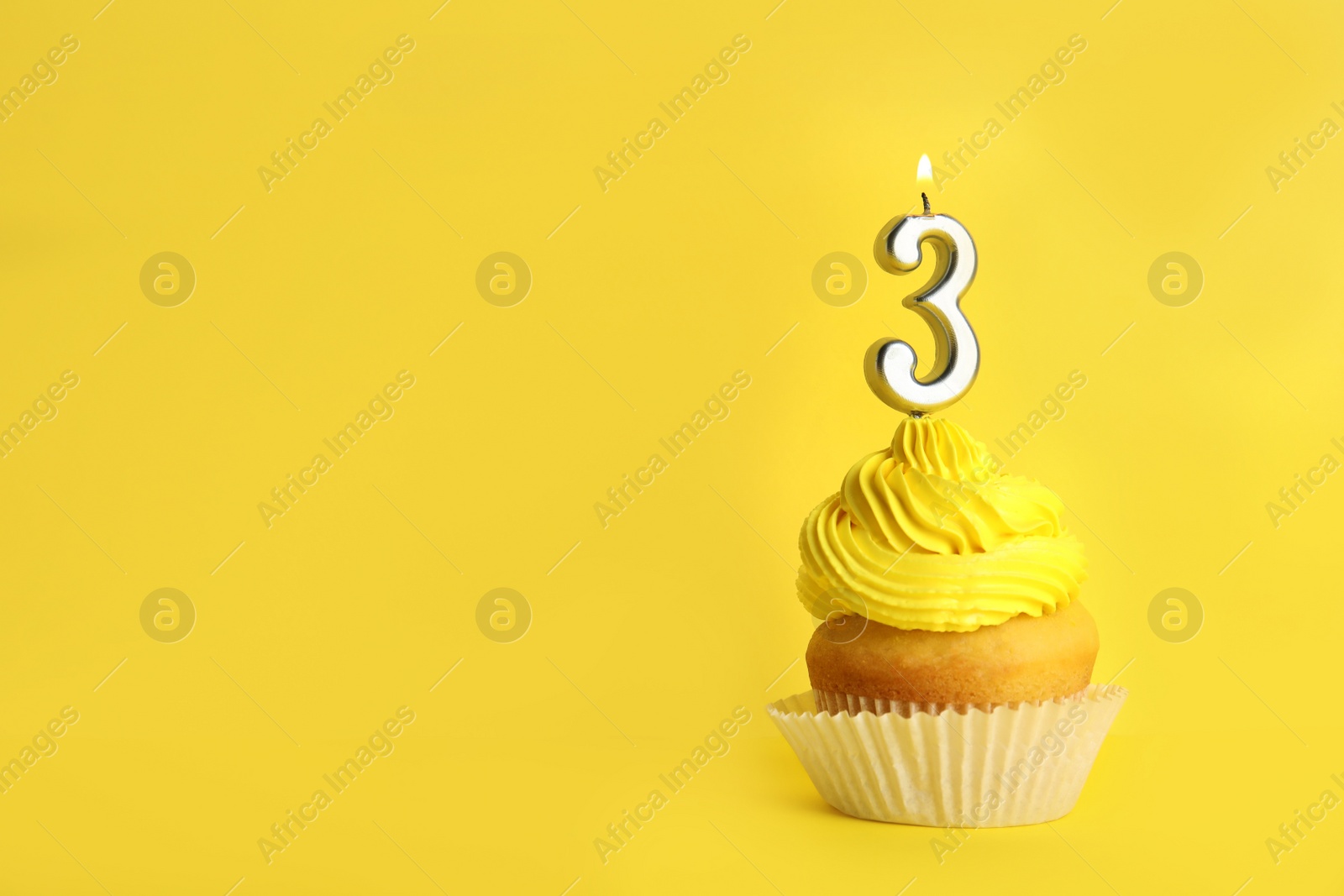 Photo of Birthday cupcake with number three candle on yellow background, space for text