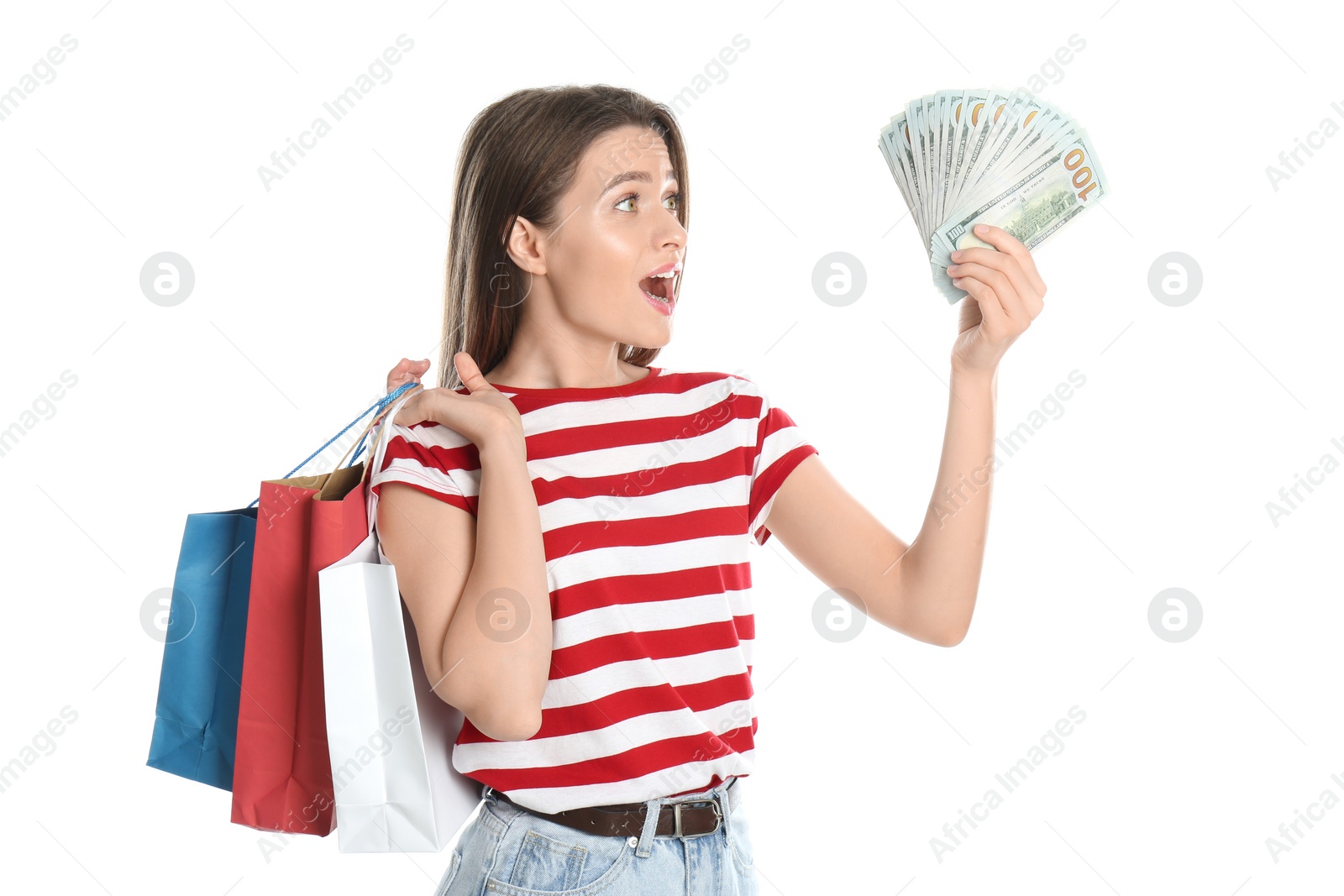 Photo of Emotional young woman with money and shopping bags on white background