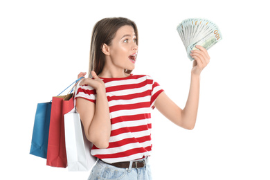 Photo of Emotional young woman with money and shopping bags on white background