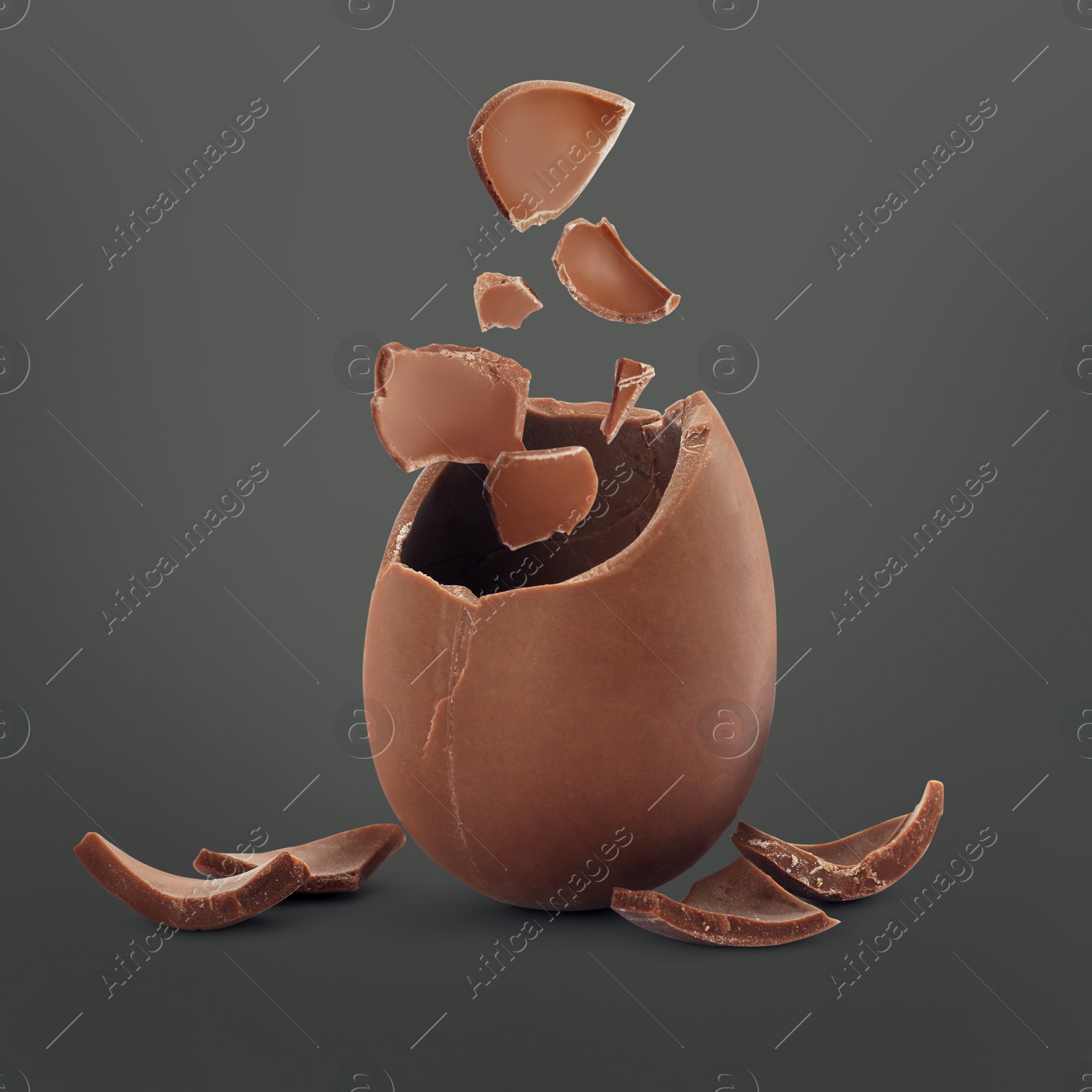 Image of Exploded milk chocolate egg on dark grey background