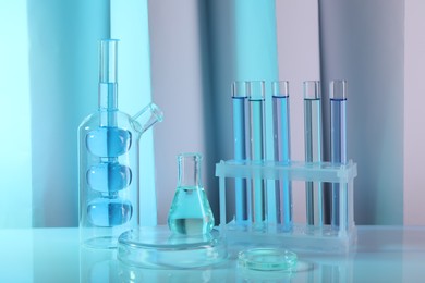 Photo of Laboratory analysis. Different glassware on table against color background