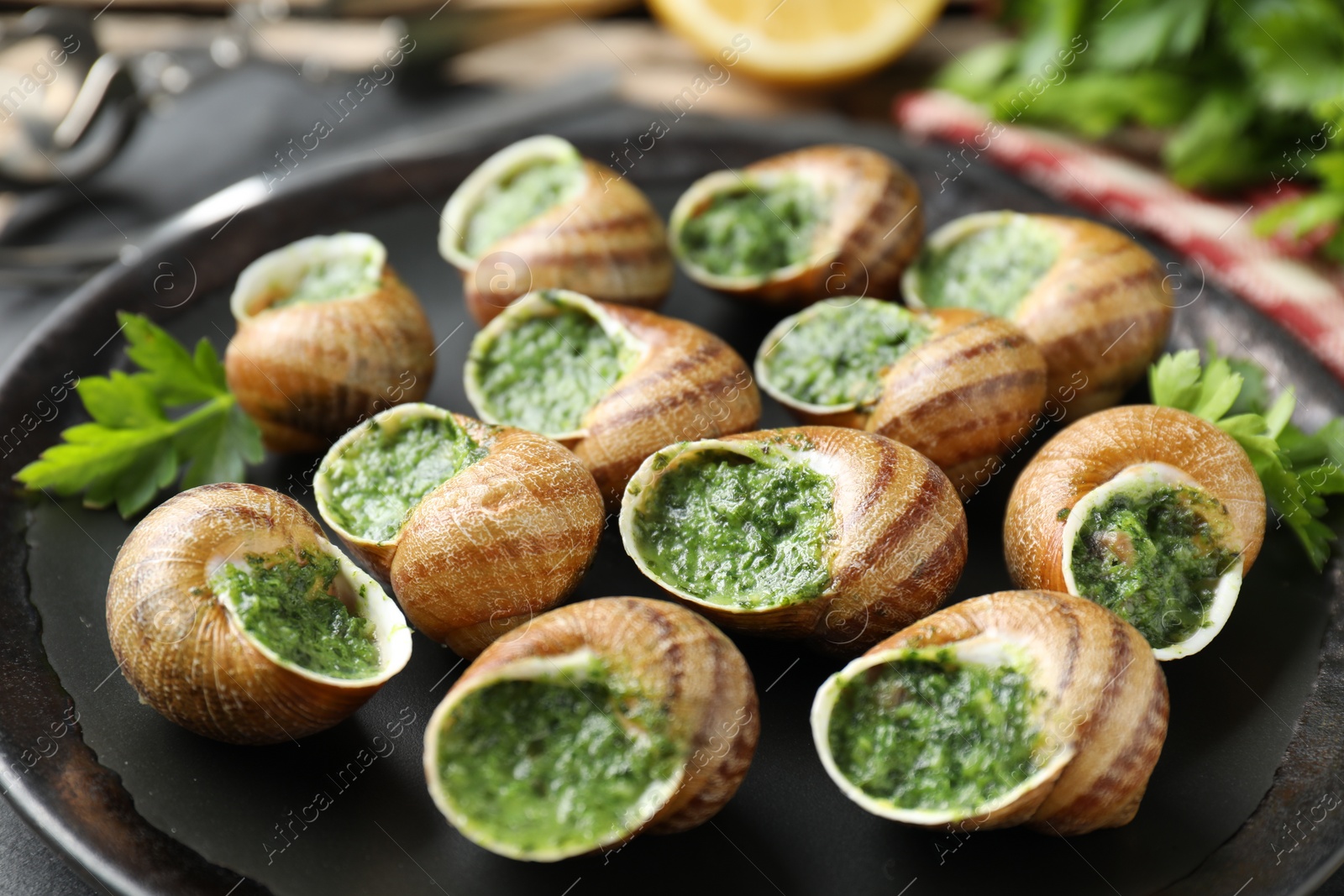 Photo of Delicious cooked snails with parsley on table, closeup