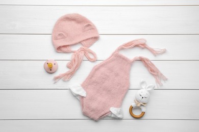 Photo of Flat lay composition with child's clothes and accessories on white wooden table