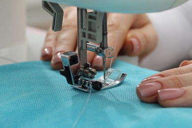 Photo of Seamstress working with sewing machine indoors, selective focus