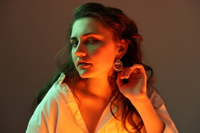 Photo of Portrait of beautiful young woman on color background with neon lights