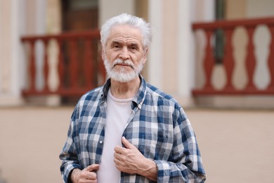 Photo of Portrait of happy grandpa with grey hair outdoors