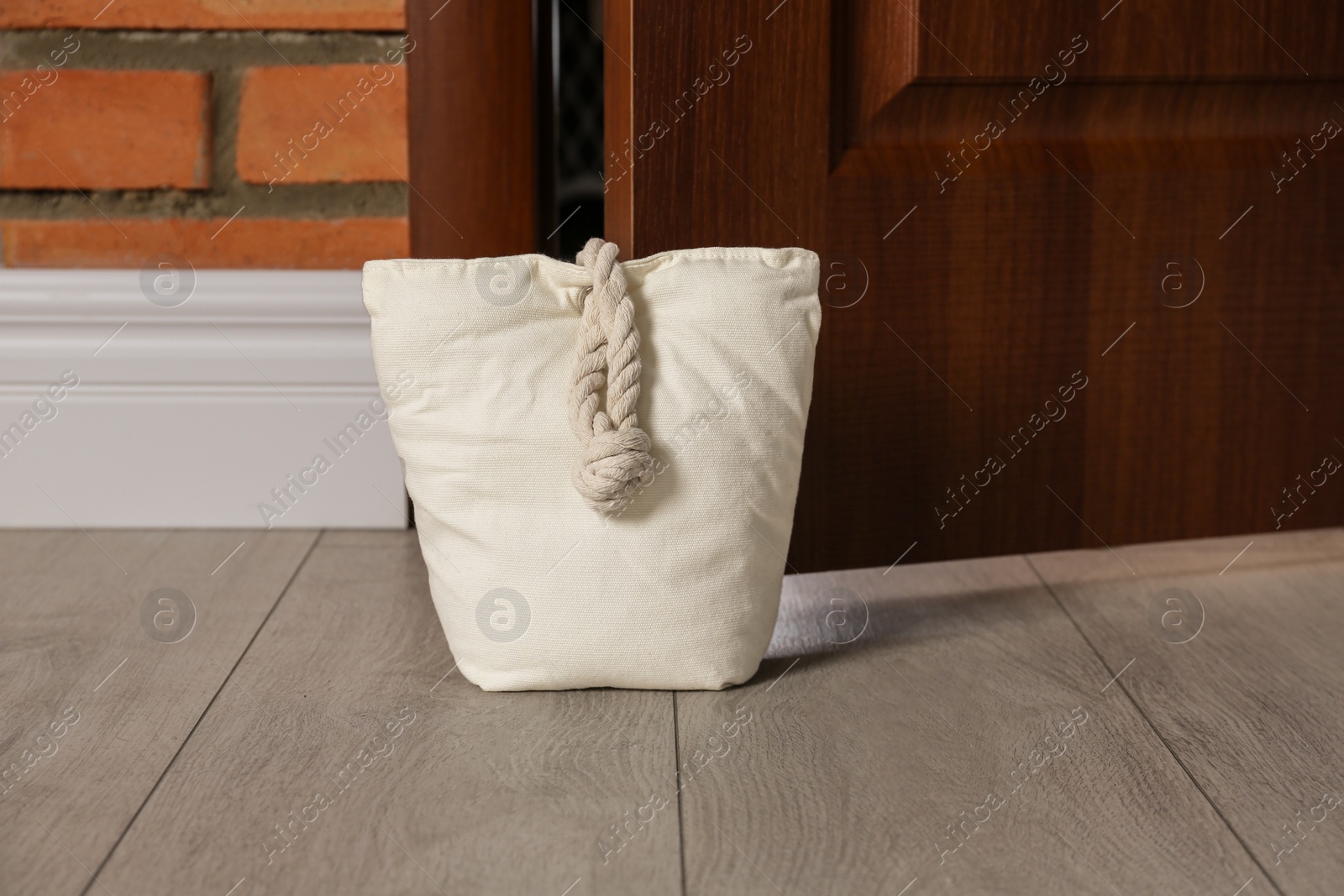 Stuffed bag holding wooden door at home Photo of Stuffed bag holding wooden door at home