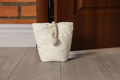 Photo of Stuffed bag holding wooden door at home