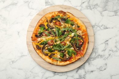 Photo of Delicious vegetarian pizza with mushrooms, vegetables and arugula on white marble table, top view