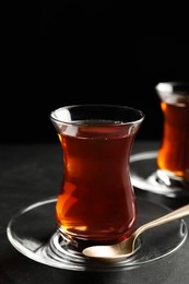 Photo of Glasses with traditional Turkish tea on black table