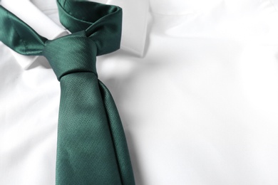 Photo of Color male necktie on white shirt, closeup. Space for text