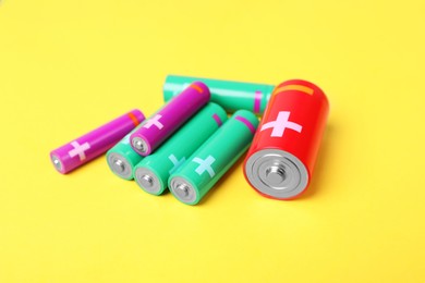 Different types of batteries on yellow background