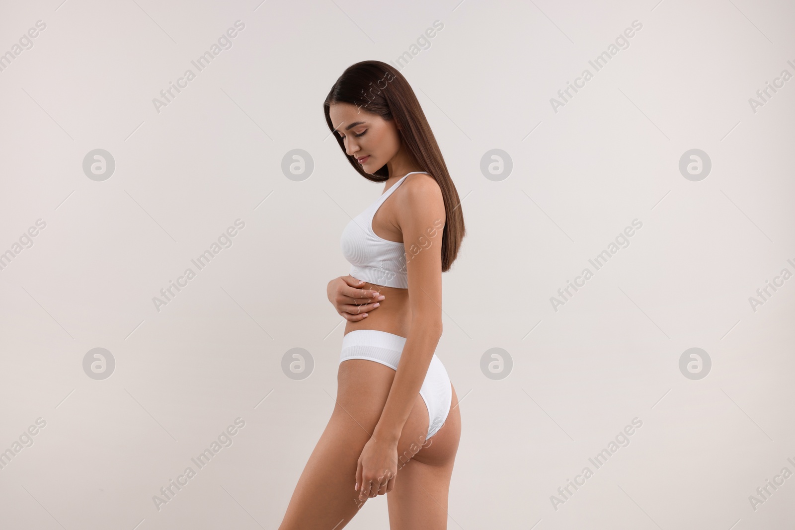 Photo of Young woman in stylish bikini on white background