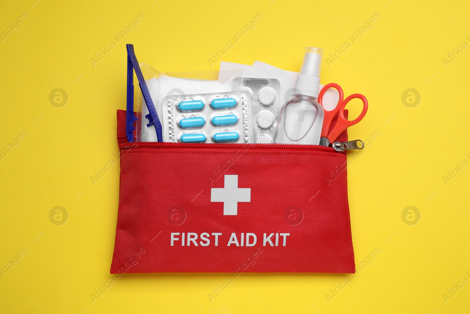 Photo of First aid kit on yellow background, top view