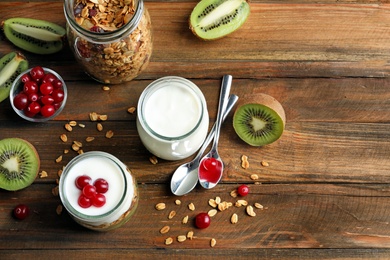 Photo of Tasty breakfast with yogurt and granola on wooden table