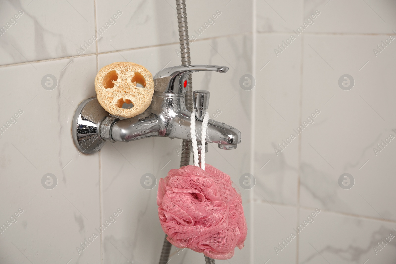 Photo of Different sponges on faucet in bathroom, space for text