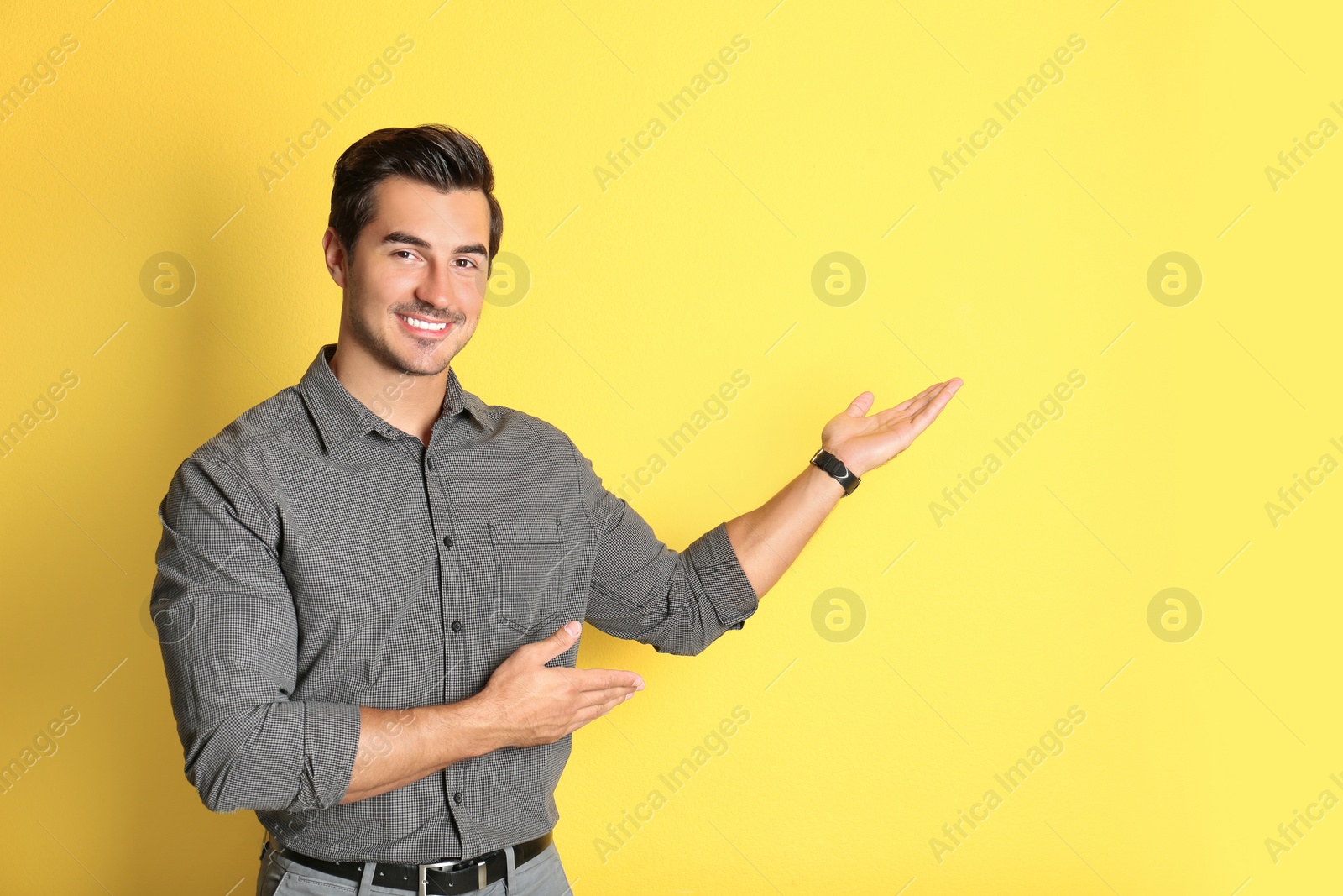 Photo of Young male teacher on yellow background. Space for text