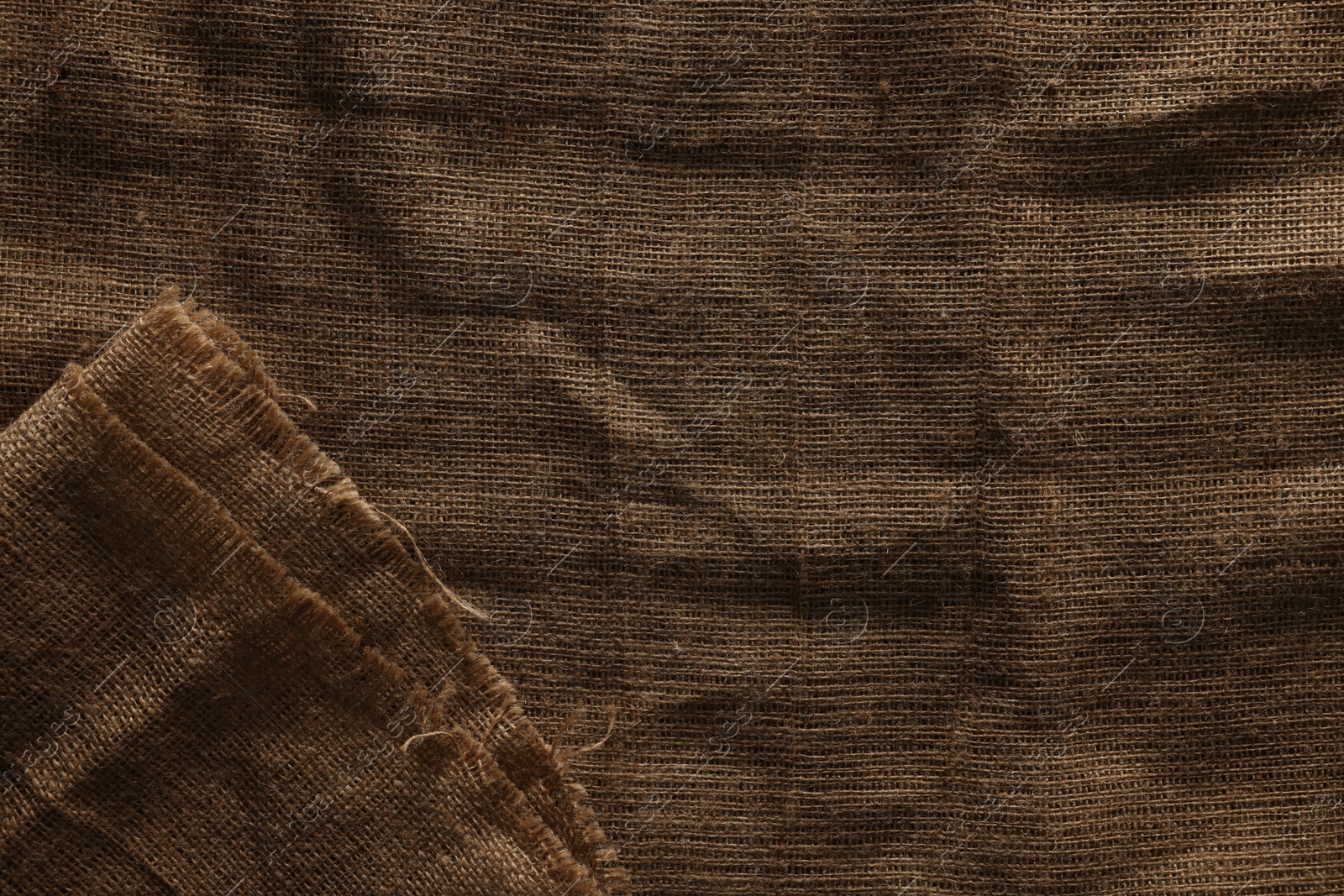 Photo of Texture of natural burlap fabric as background, top view