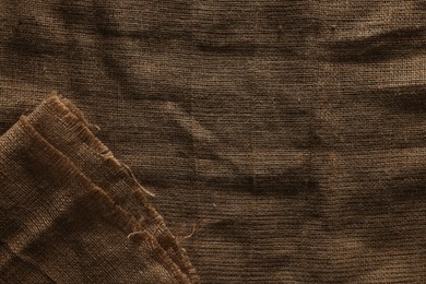 Photo of Texture of natural burlap fabric as background, top view