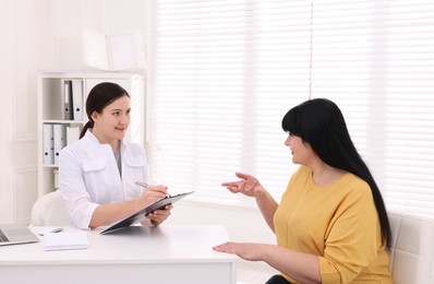 Overweight mature woman consulting with nutritionist in clinic