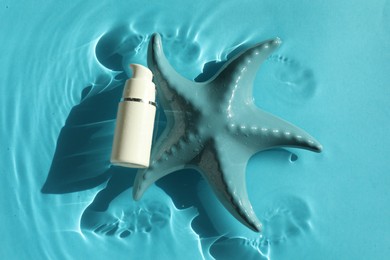 Moisturizing cream and sea star in water on light blue background, top view