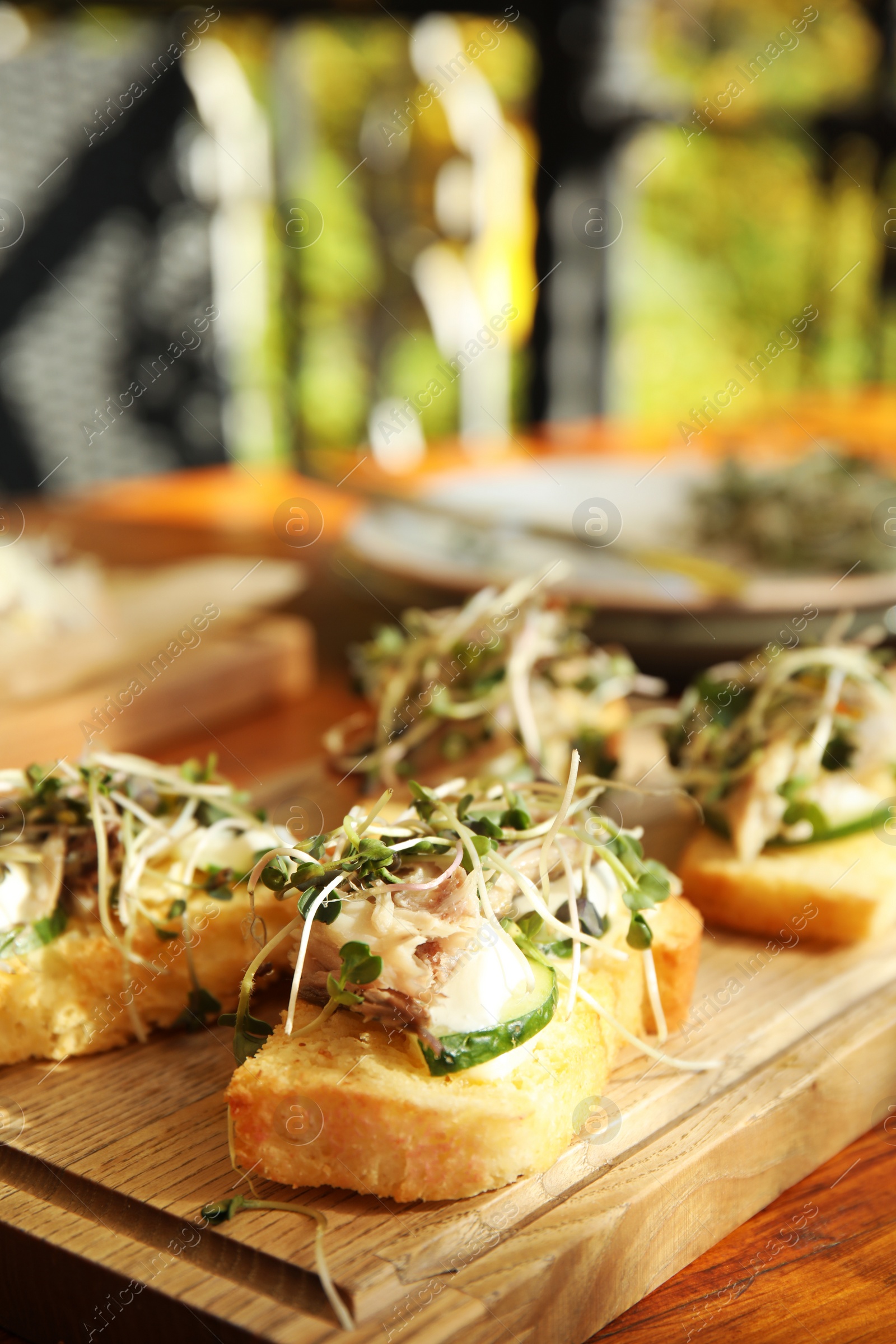 Photo of Delicious bruschettas with fish on wooden table