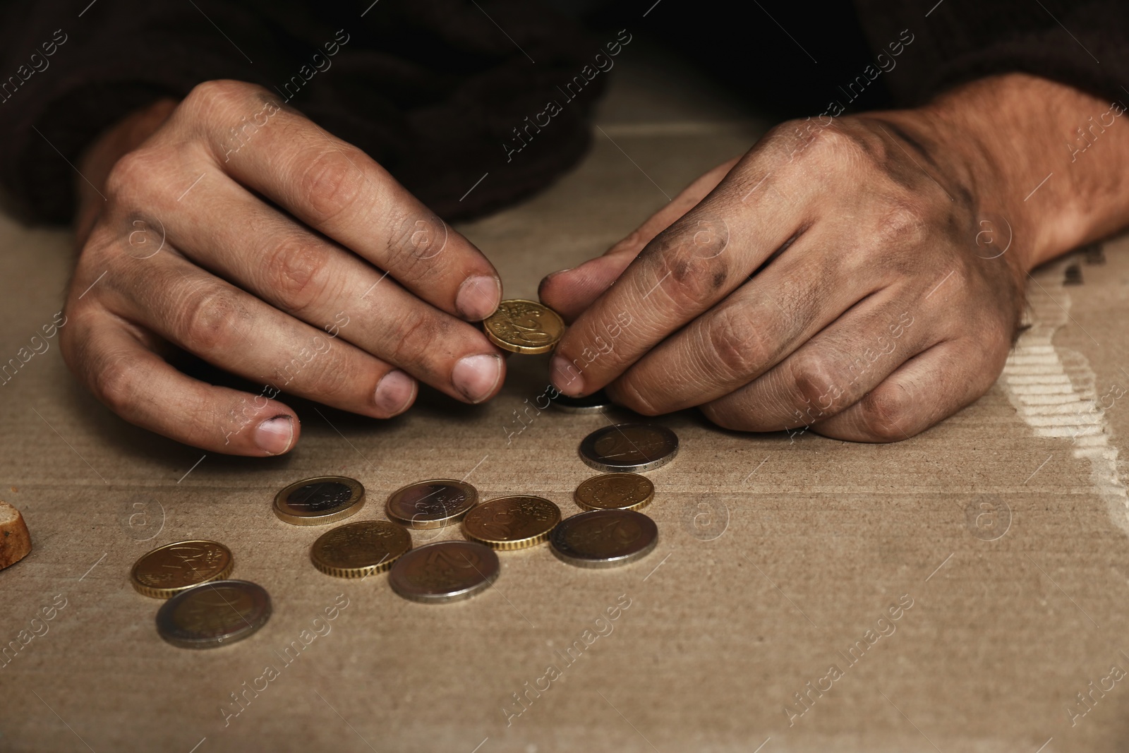 Photo of Poor homeless man counting coins on floor, focus on hands