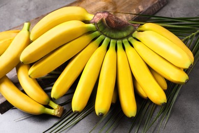 Photo of Tasty ripe baby bananas on grey table