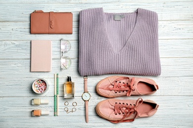 Flat lay composition with clothes, cosmetics and stylish accessories on light background