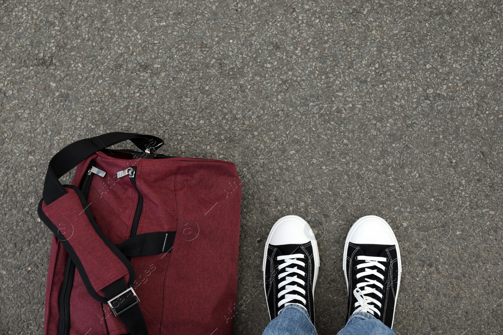 Photo of Man with bag standing on asphalt, top view. Space for text