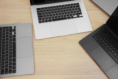 Photo of Different laptops on wooden table. Modern technology