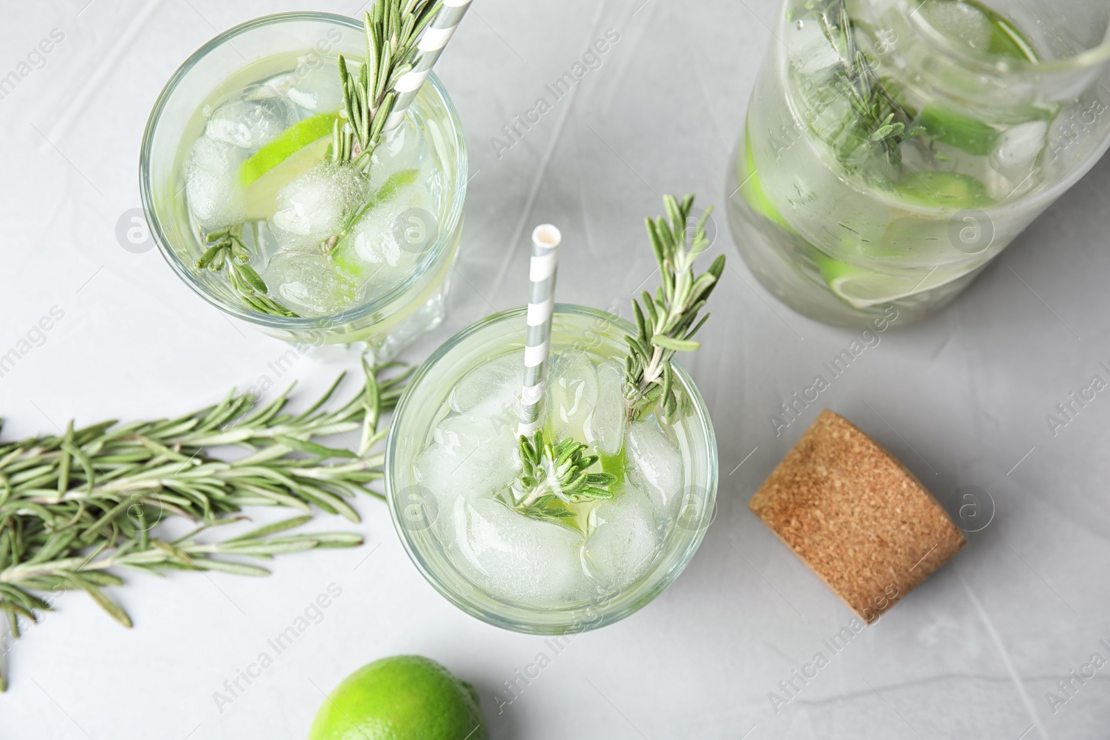 Photo of Flat lay composition with lime and rosemary cocktail on gray table